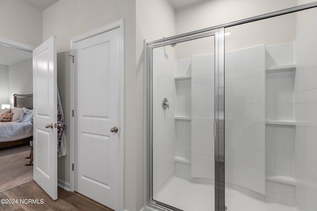 bathroom featuring hardwood / wood-style floors and a shower with door