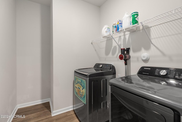 laundry area with dark wood-type flooring and washer and dryer