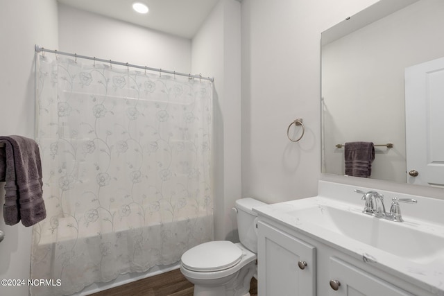 full bathroom with hardwood / wood-style floors, vanity, toilet, and shower / bath combo with shower curtain