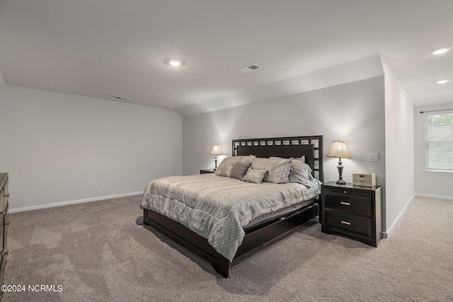 bedroom featuring light carpet and vaulted ceiling