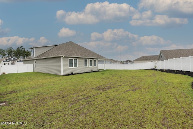 rear view of property featuring a lawn