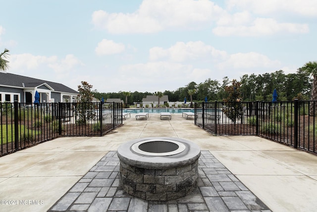 view of patio / terrace featuring an outdoor fire pit and a community pool