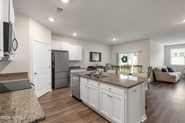 kitchen featuring white cabinets, an island with sink, and stainless steel appliances