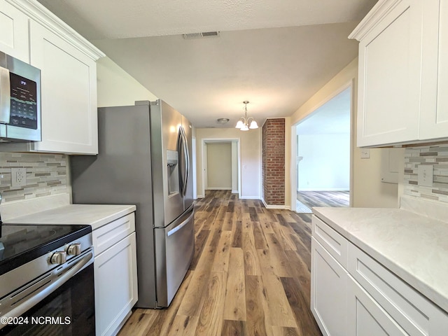 kitchen featuring a notable chandelier, white cabinetry, appliances with stainless steel finishes, and tasteful backsplash