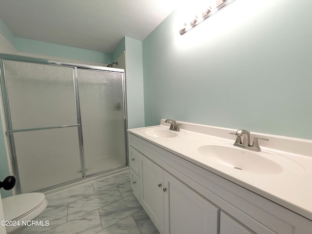 bathroom with a shower with door, vanity, and toilet