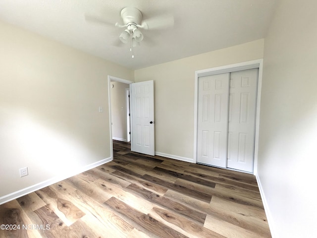 unfurnished bedroom featuring dark hardwood / wood-style flooring, a closet, and ceiling fan