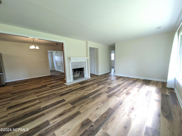 unfurnished living room with dark hardwood / wood-style flooring and a chandelier