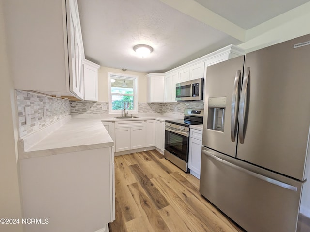 kitchen featuring white cabinetry, sink, appliances with stainless steel finishes, and tasteful backsplash