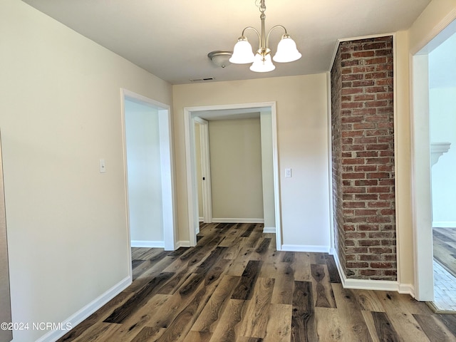 corridor featuring a chandelier and dark wood-type flooring