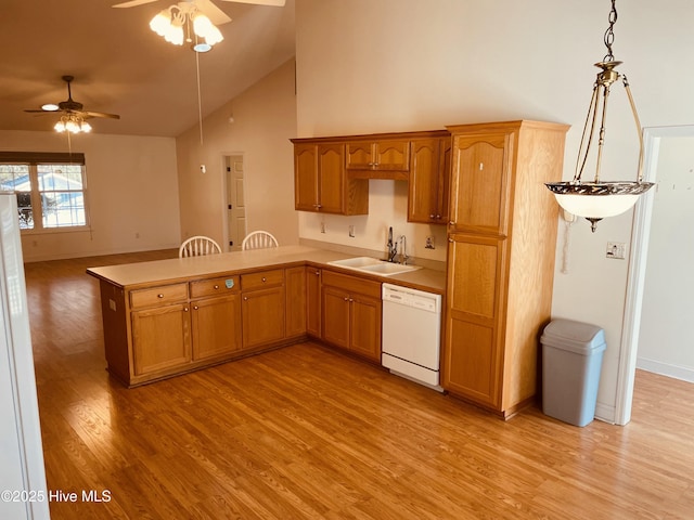 kitchen featuring sink, light hardwood / wood-style floors, kitchen peninsula, white dishwasher, and hanging light fixtures