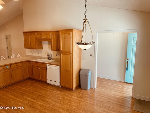 kitchen with dishwasher, decorative light fixtures, lofted ceiling, light wood-type flooring, and sink