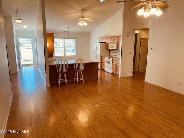 kitchen with white appliances, ceiling fan, decorative light fixtures, and wood-type flooring