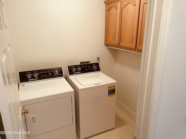 clothes washing area with cabinets and washing machine and dryer