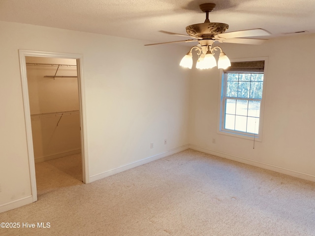 carpeted spare room with a textured ceiling and ceiling fan