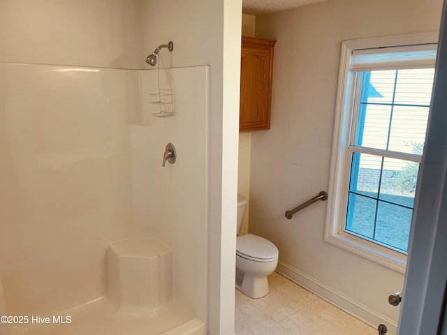 bathroom featuring walk in shower and toilet