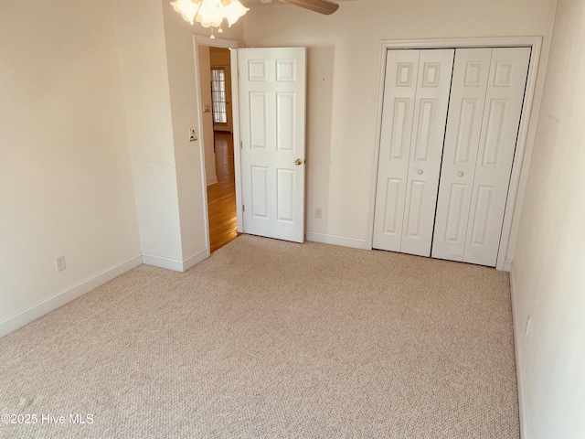 unfurnished bedroom featuring ceiling fan, a closet, and light carpet