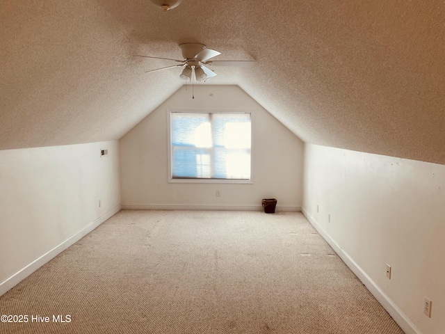 additional living space with vaulted ceiling, ceiling fan, and light carpet