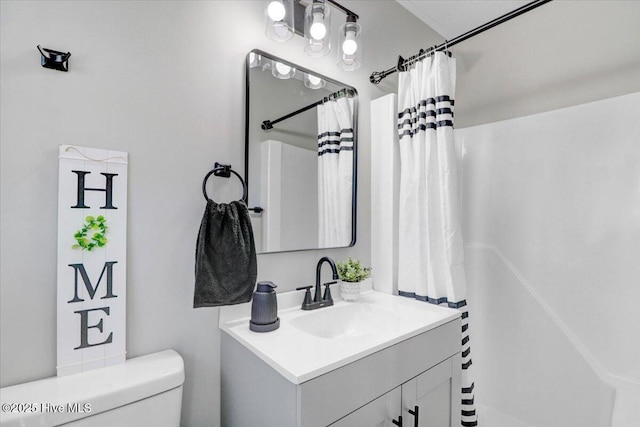 bathroom featuring walk in shower, vanity, and toilet