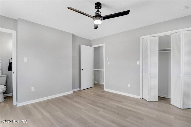 unfurnished bedroom featuring ensuite bathroom, ceiling fan, light hardwood / wood-style floors, and a closet