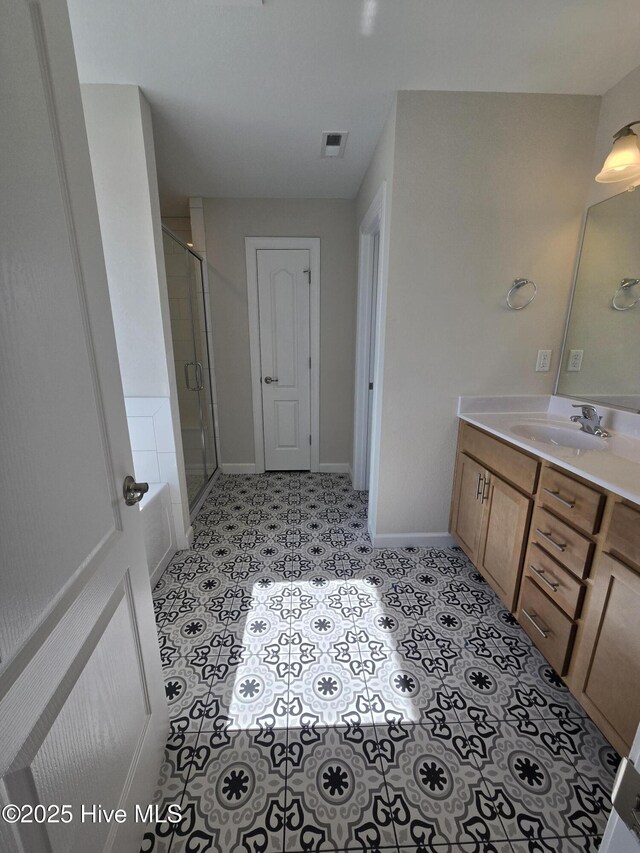 bathroom with tile patterned floors, vanity, and an enclosed shower