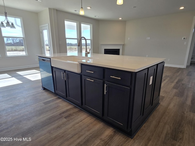 kitchen with stainless steel dishwasher, an island with sink, and hanging light fixtures