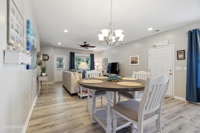 dining room featuring ceiling fan with notable chandelier and light hardwood / wood-style flooring