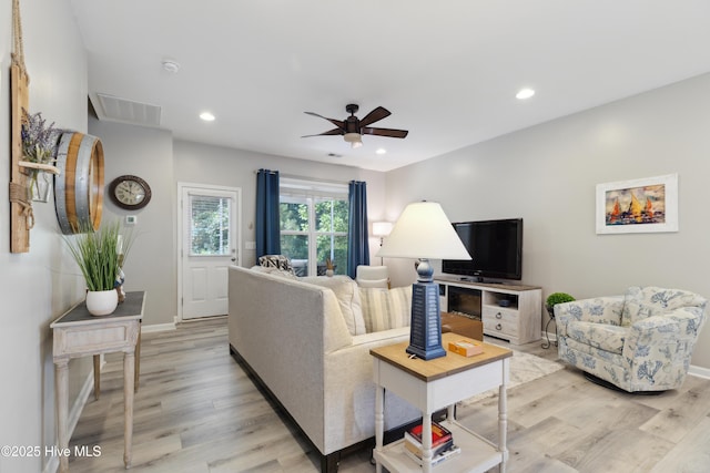 living room with ceiling fan and light hardwood / wood-style flooring