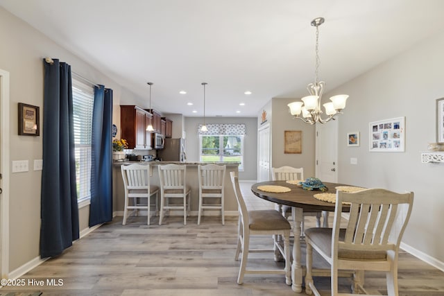 dining room featuring a notable chandelier and light wood-type flooring