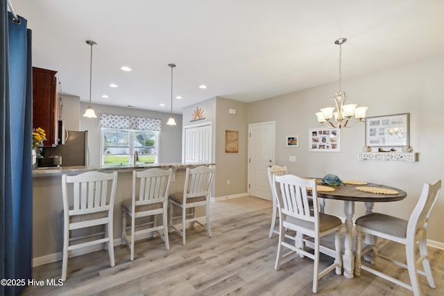 dining room featuring an inviting chandelier, light hardwood / wood-style flooring, and sink