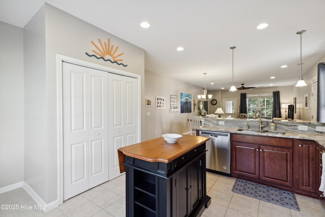 kitchen featuring ceiling fan, dishwasher, a kitchen island, light stone counters, and sink