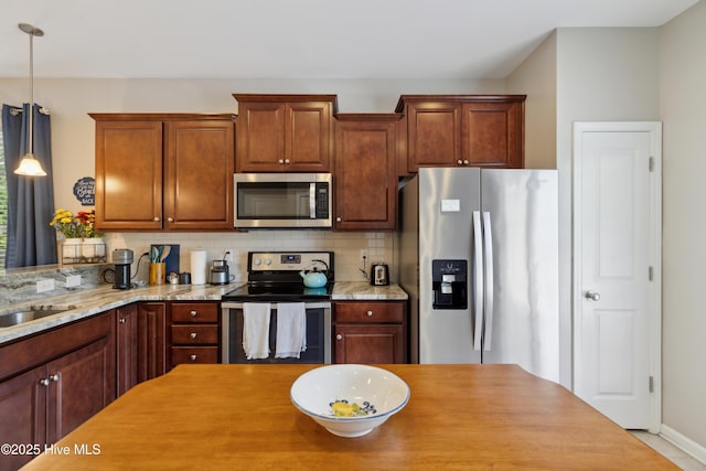 kitchen featuring decorative backsplash, decorative light fixtures, appliances with stainless steel finishes, and light stone countertops