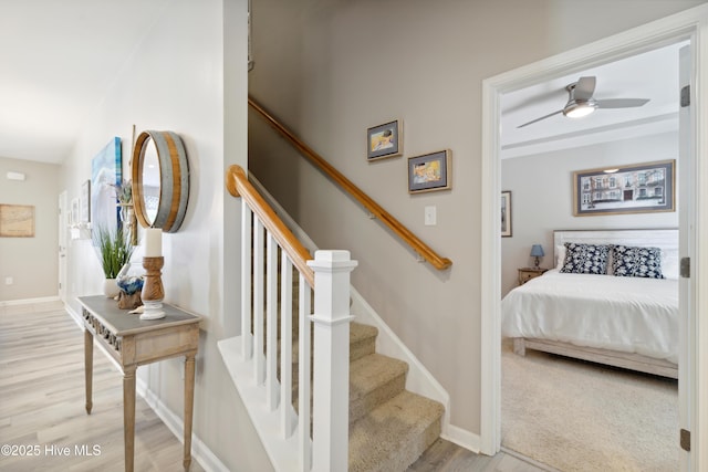 stairway with ceiling fan and wood-type flooring