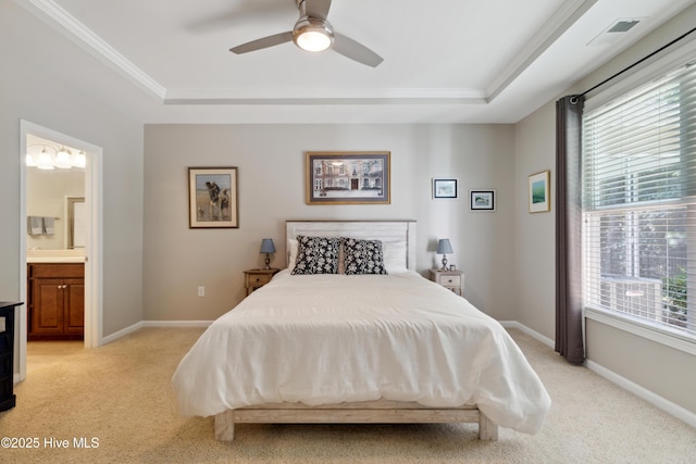 bedroom featuring ceiling fan, light colored carpet, connected bathroom, and a raised ceiling