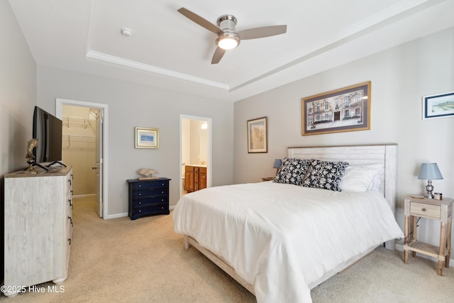 bedroom with a raised ceiling, a walk in closet, ceiling fan, and a closet