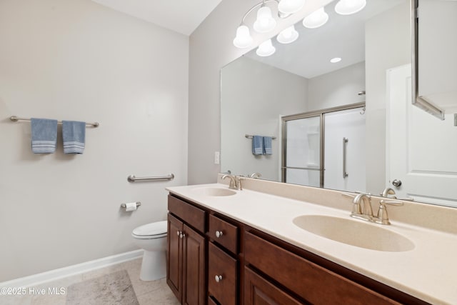 bathroom with toilet, tile patterned floors, vanity, and a shower with shower door