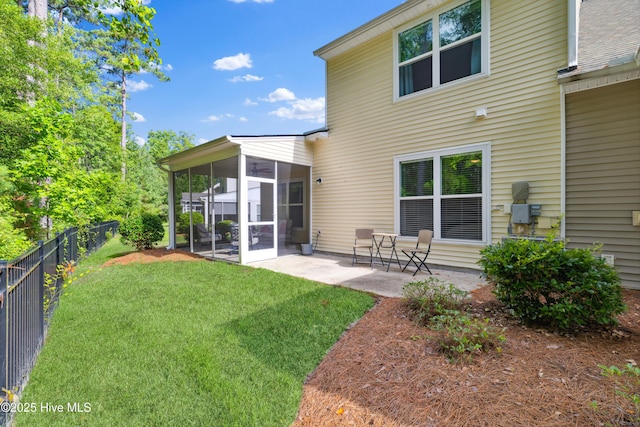 back of house featuring a patio area, a sunroom, and a yard