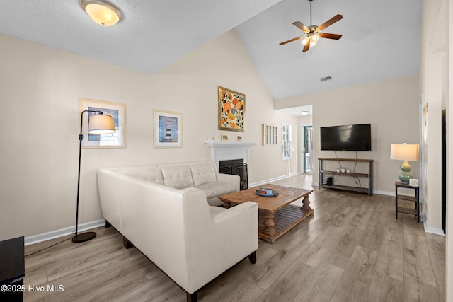 living room with high vaulted ceiling, light hardwood / wood-style flooring, and ceiling fan