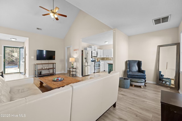 living room with light hardwood / wood-style floors, high vaulted ceiling, and ceiling fan