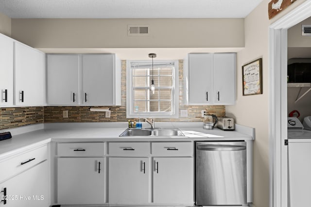 kitchen featuring tasteful backsplash, sink, separate washer and dryer, decorative light fixtures, and white cabinetry