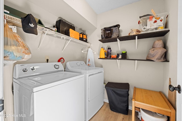 laundry room featuring washer and dryer and light hardwood / wood-style floors