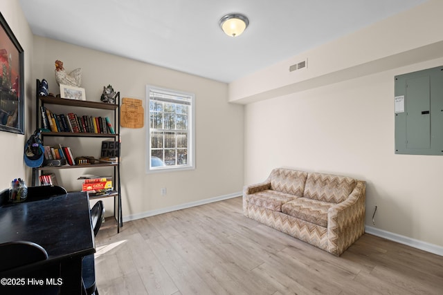 sitting room featuring electric panel and light hardwood / wood-style floors