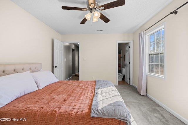 carpeted bedroom featuring ensuite bath and ceiling fan