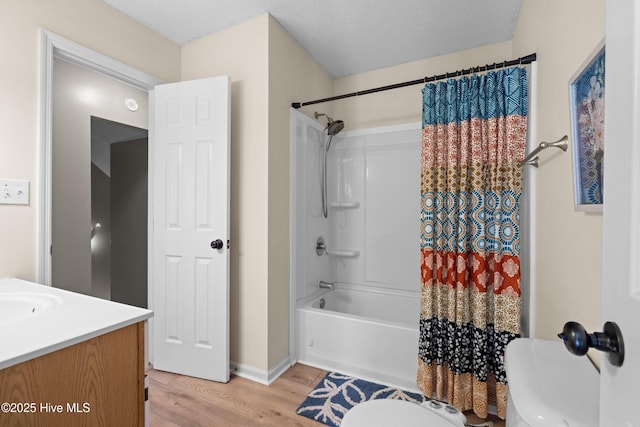 full bathroom featuring vanity, a textured ceiling, shower / tub combo with curtain, hardwood / wood-style flooring, and toilet