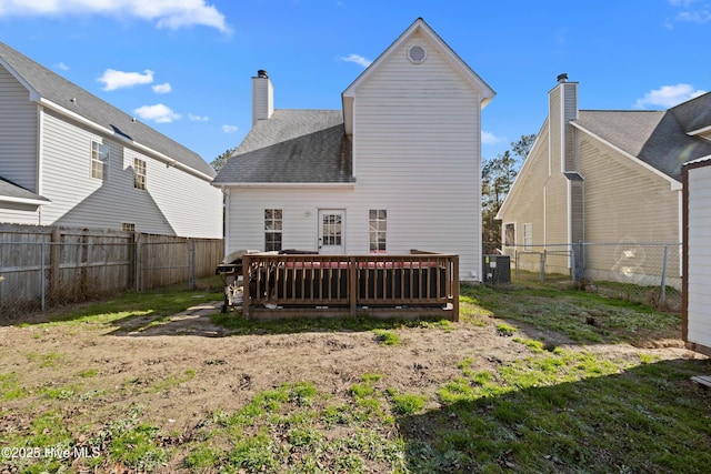 back of property with a yard, central air condition unit, and a wooden deck