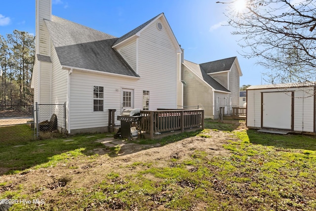 rear view of house with a wooden deck, a yard, and a shed