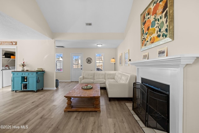 living room with light hardwood / wood-style flooring and lofted ceiling