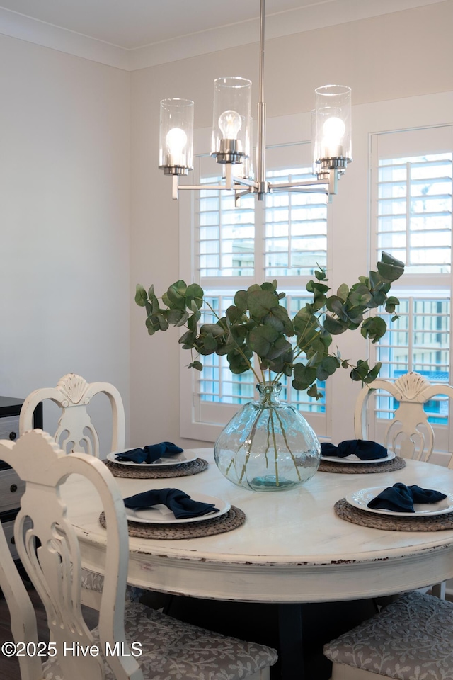 dining room featuring crown molding, plenty of natural light, and an inviting chandelier