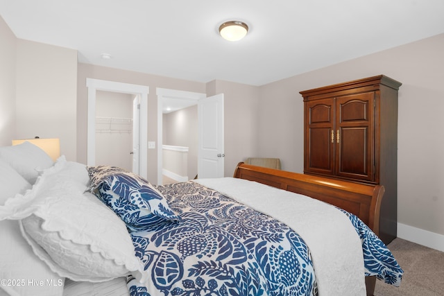 bedroom featuring a walk in closet, carpet floors, and a closet