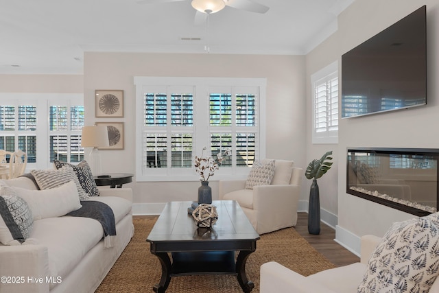 living room with hardwood / wood-style floors, ceiling fan, and crown molding