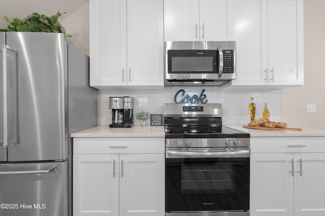 kitchen with backsplash, white cabinets, and appliances with stainless steel finishes